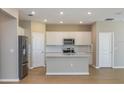 Bright kitchen featuring stainless steel appliances, white cabinets, a center island, and sleek countertops at 5329 Sw 81St Cir, Ocala, FL 34481
