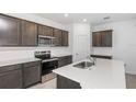 Bright kitchen featuring an island with sink, stainless steel appliances, gray cabinets, and tiled backsplash at 8223 Sw 52Nd Lane Rd, Ocala, FL 34481