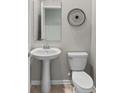 Small bathroom with pedestal sink and toilet at 1848 Bright Sky Dr, Kissimmee, FL 34744