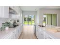 Gourmet kitchen showcases white cabinets, an island, stainless steel appliances, and overlooks the backyard at 5222 Sw 88Th Cir, Ocala, FL 34481
