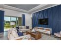 Inviting living room with large windows and elegant blue accent wall at 5222 Sw 88Th Cir, Ocala, FL 34481