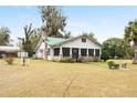 White house with green roof and screened porch, on a grassy lot at 15220 Nw 41St Ter, Reddick, FL 32686