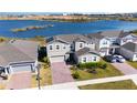 Two-story house with lake view, solar panels, and brick paver driveway at 3200 Canna Lily Pl, Clermont, FL 34711