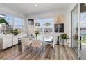 Elegant dining room with a modern glass table, bright windows, and lovely outdoor views at 3200 Canna Lily Pl, Clermont, FL 34711