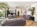 Beautiful living room with stairs to second level, a piano, plush seating, and light wood floors at 3200 Canna Lily Pl, Clermont, FL 34711