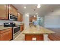 Kitchen with granite island, wood cabinets, and stainless steel appliances at 3537 Raleigh Dr, Winter Haven, FL 33884