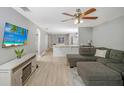 Open living area featuring a sectional sofa, hardwood floors, and a view into the kitchen at 1314 W Highland St, Lakeland, FL 33815