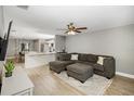 Open living area featuring a sectional sofa, hardwood floors, and a view into the kitchen at 1314 W Highland St, Lakeland, FL 33815
