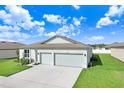 Single story home with a two-car garage and grassy yard at 1125 Michelangelo Ln, Winter Haven, FL 33884