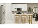 Modern kitchen with white cabinets, island, and stainless steel appliances at 502 Puma Loop, Groveland, FL 34736
