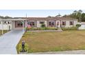Tan manufactured home with red trim, carport, and American flag at 555 Lindsey Dr, Lakeland, FL 33809