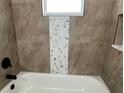 Close-up of a bathroom with hexagon tile accent and a bathtub at 5349 Hidden Oaks Dr, Lakeland, FL 33811