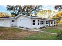 Newly renovated home with a white exterior, black windows, and landscaping at 3720 Willis Rd, Mulberry, FL 33860