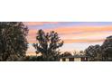 A home sits beneath a picturesque sky; large trees covered with Spanish moss frame the structure at 8309 W Lake Marion Rd, Haines City, FL 33844
