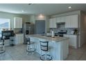 Open kitchen with a large island, stainless steel appliances, white cabinetry, and modern backsplash at 637 Bernard Ln, Davenport, FL 33837