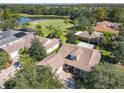Aerial view of a beautiful home near a golf course and lake, surrounded by lush greenery and other residences at 417 Lake Butler Dr, Kissimmee, FL 34759