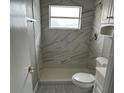 Updated bathroom with a walk-in shower and gray marble tile at 1703 Mona Ave, Ocoee, FL 34761