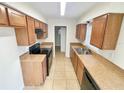 Efficient kitchen featuring wood cabinets, a black range, laminate counters, and tile flooring at 4211 Spring Ln, Lakeland, FL 33811