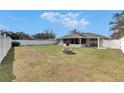 Spacious fenced backyard with a well-kept lawn, fire pit, and covered patio, ideal for outdoor living at 1060 Colony Park Dr, Lakeland, FL 33813