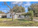 Lovely single-story home features a front-facing garage, a manicured lawn, and mature trees providing natural shade at 116 Woodlane Ave, Wildwood, FL 34785