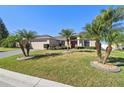 Charming home boasts mature palm trees across the front yard with meticulously maintained landscaping at 8867 Pebblebrooke Dr, Lakeland, FL 33810