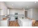 Spacious kitchen showcasing white cabinets, a large center island, modern appliances, and stylish barstool seating at 5295 Sw 87Th Ter, Ocala, FL 34481