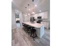 Modern kitchen with white cabinets, a large island, and stainless steel appliances at 309 Burrowing Owl Ln, Winter Haven, FL 33880