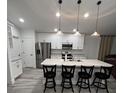 Modern kitchen with white cabinets, a large island, and stainless steel appliances at 309 Burrowing Owl Ln, Winter Haven, FL 33880