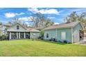 Lush green backyard featuring a screened-in porch, a well, and detached garage at 506 Parrott Rd, Auburndale, FL 33823