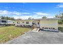 Inviting yellow single-story home features a ramp, tidy landscaping and an RV parked in the background at 1220 George St, Winter Springs, FL 32708