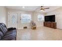 Inviting living room with a rocking chair, tile flooring, and a view of the decorative front door at 1220 George St, Winter Springs, FL 32708