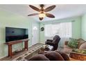 Cozy living room with neutral walls, a ceiling fan, a comfortable seating arrangement, and a window at 38 Seaside Dr, Ormond Beach, FL 32176