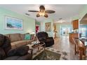 Inviting living room features wood floors, a ceiling fan, comfortable seating, and views into the kitchen and dining area at 38 Seaside Dr, Ormond Beach, FL 32176