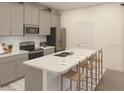 A well-appointed kitchen featuring gray cabinetry, stainless appliances and a quartz breakfast bar at 5896 Meditation Dr, Clermont, FL 34714