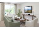 A view of a sunlit living room featuring a large window, neutral decor and stylish furnishings at 5896 Meditation Dr, Clermont, FL 34714