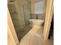 Bathroom features a glass-enclosed shower and a separate soaking tub at 3088 Pointe Place Ave, Kissimmee, FL 34758