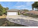 Spacious driveway leading to a charming one-story home with a two-car garage at 562 Dowling Cir, Lady Lake, FL 32159