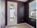 Elegant entryway with tiled floor, featuring a stylish glass door and a window with blinds at 6973 Wilson Pasture Ave, Groveland, FL 34736