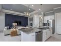 Modern kitchen with stainless steel appliances, granite countertops, a blue accent wall and open to living area at 9151 Sw 52Nd Place Rd, Ocala, FL 34481