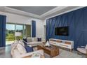 Stylish living room features modern furniture, a sliding glass door and a captivating blue accent wall with TV at 9151 Sw 52Nd Place Rd, Ocala, FL 34481