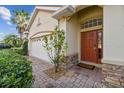 Inviting entryway with a brick walkway, lush landscaping, and a stylish front door at 1713 Altavista Cir, Lakeland, FL 33810