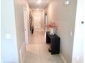 Bright hallway featuring tile flooring, a console table with decor, and fresh neutral paint at 2206 Old Mining Rd, Lakeland, FL 33801