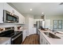Well-equipped kitchen with stainless steel appliances, ample cabinet space, solid surface counters, and wood flooring at 1600 Ellesmere Ave, Haines City, FL 33844