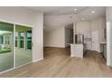 Open floor plan featuring a modern kitchen and sun-filled living area with sliding glass doors at 1604 Ellesmere Ave, Haines City, FL 33844