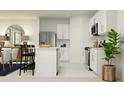 Bright kitchen featuring white cabinetry, stainless steel appliances, and an island with bar stool seating at 3411 Howell Dr, Lake Wales, FL 33859