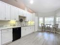 Bright kitchen featuring white cabinets, gray countertops, and a cozy breakfast nook with views of the outdoors at 3931 Tano Dr, Ormond Beach, FL 32174