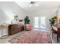 Bright living room with vaulted ceilings, decorative rug, and French doors leading to the outdoor pool area at 3931 Tano Dr, Ormond Beach, FL 32174