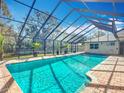 Sparkling pool is showcased within a screened enclosure and brick poolside at 3931 Tano Dr, Ormond Beach, FL 32174