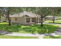 Angle view of a one-story home with neat landscaping, mature trees and sidewalks at 416 Country View Cir, Deland, FL 32720