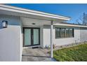 Inviting front entrance with modern double doors and tiled walkway at 2310 Laguna Dr, Indian Lake Estates, FL 33855